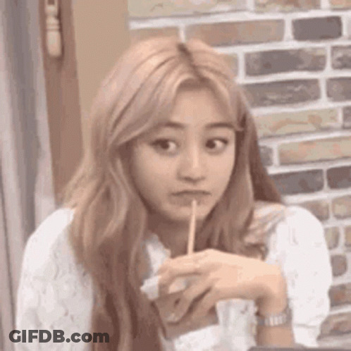 A Woman With Long Blonde Hair Is Holding A Toothpick In Her Mouth . GIF