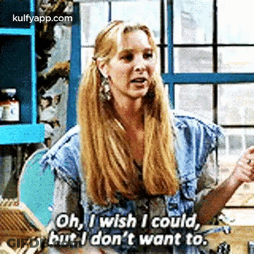 A Woman With Long Blonde Hair Is Sitting At A Table And Talking To A Man . GIF