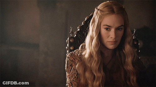 A Woman With Long Blonde Hair Is Sitting In A Chair And Looking At The Camera GIF