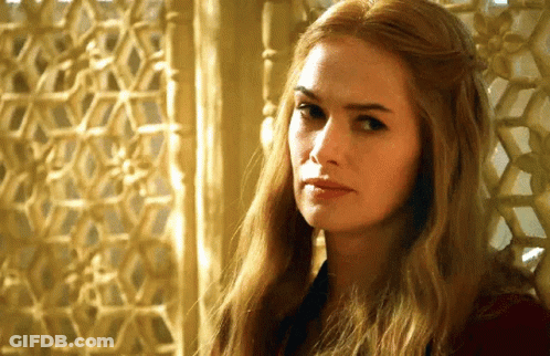 A Woman With Long Blonde Hair Is Sitting In Front Of A Window Looking At The Camera . GIF