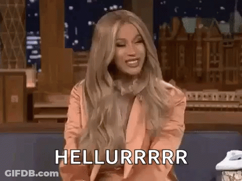 A Woman With Long Blonde Hair Is Sitting On A Couch And Smiling While Talking On A Phone . GIF