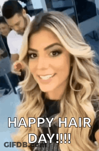 A Woman With Long Blonde Hair Is Smiling And Looking At The Camera With The Words `` Happy Hair Day ! '' GIF