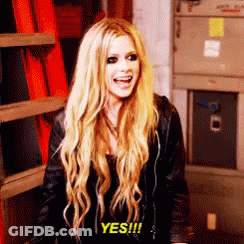 A Woman With Long Blonde Hair Is Smiling And Saying Yes . GIF
