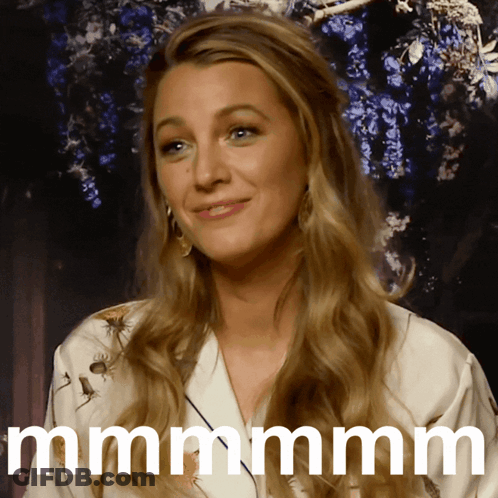 A Woman With Long Blonde Hair Is Smiling And Says Mmmm GIF