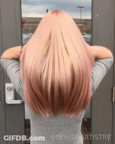 A Woman With Long Blonde Hair Is Standing In Front Of A Door With The Words @Mrhairartistry On The Bottom GIF