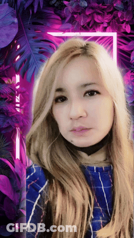 A Woman With Long Blonde Hair Is Standing In Front Of A Purple Background GIF