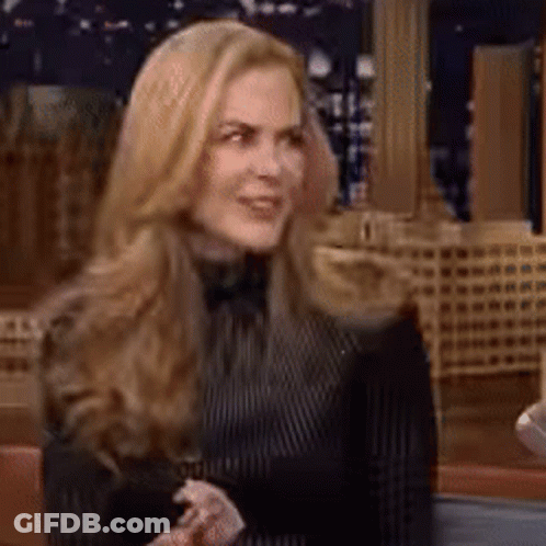 A Woman With Long Blonde Hair Is Wearing A Black And White Striped Shirt GIF