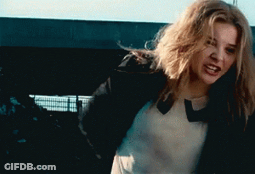 A Woman With Long Blonde Hair Is Wearing A Black Jacket GIF