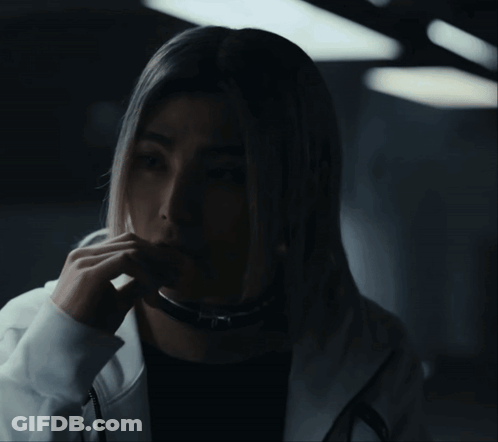 A Woman With Long Blonde Hair Is Wearing A Black Shirt And A White Hoodie GIF