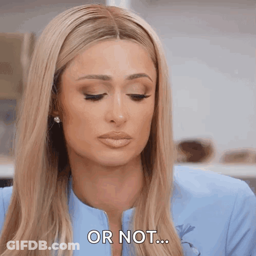 A Woman With Long Blonde Hair Is Wearing A Blue Jacket And Earrings And Says Or Not . GIF