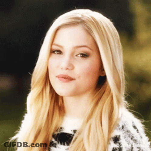 A Woman With Long Blonde Hair Is Wearing A Sweater GIF