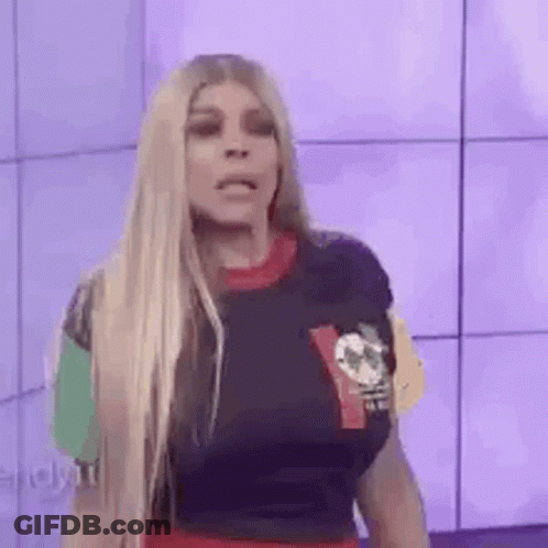 A Woman With Long Blonde Hair Is Wearing A T-Shirt With A Skull On It . GIF