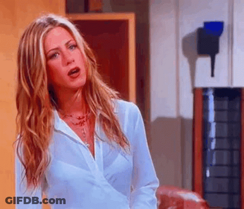 A Woman With Long Blonde Hair Is Wearing A White Shirt And Necklace . GIF