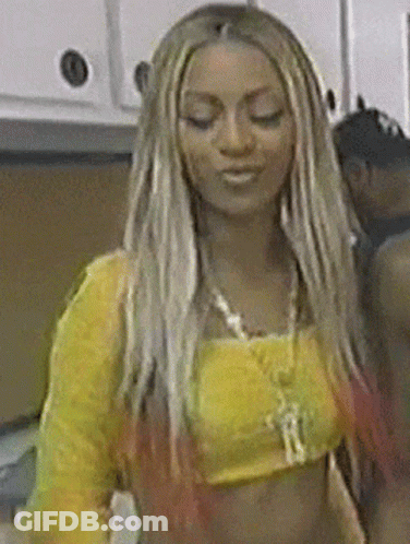 A Woman With Long Blonde Hair Is Wearing A Yellow Crop Top GIF