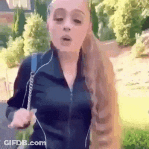 A Woman With Long Blonde Hair Is Wearing Headphones And A Black Jacket GIF