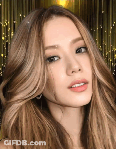 A Woman With Long Blonde Hair Looks At The Camera GIF