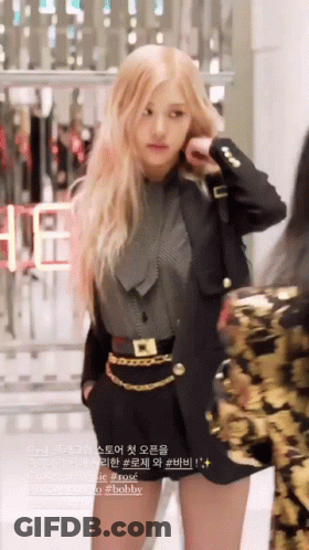 A Woman With Long Blonde Hair Wearing A Black Jacket And Shorts GIF