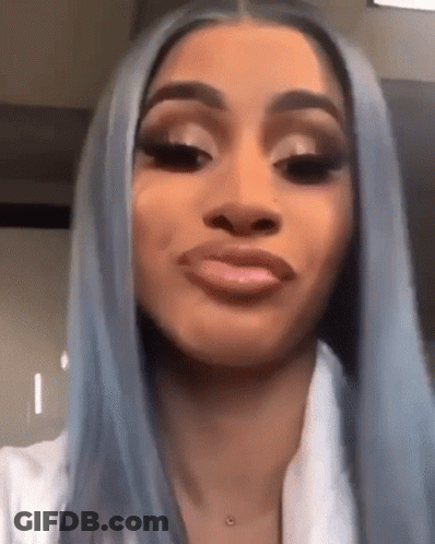 A Woman With Long Blue Hair Is Making A Funny Face . GIF