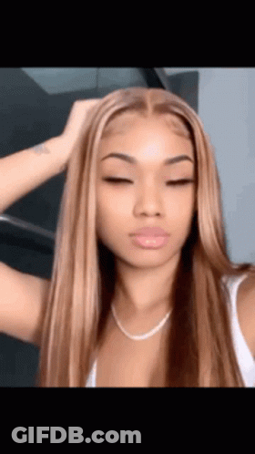 A Woman With Long Brown Hair And A White Tank Top Is Taking A Selfie With Her Eyes Closed . GIF