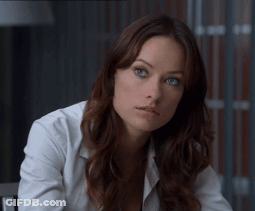 A Woman With Long Brown Hair And Blue Eyes Wearing A White Shirt GIF