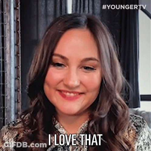 A Woman With Long Brown Hair Is Smiling And Saying `` I Love That '' . GIF
