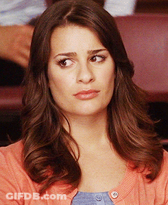 A Woman With Long Brown Hair Is Wearing A Pink Sweater And Blue Shirt GIF