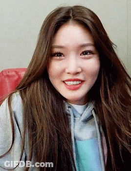 A Woman With Long Brown Hair Wearing A Grey Hoodie GIF