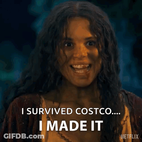 A Woman With Long Curly Hair Is Smiling And Saying `` I Survived Costco ... I Made It '' . GIF