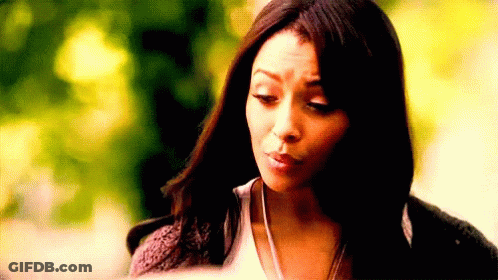 A Woman With Long Dark Hair Is Making A Funny Face GIF