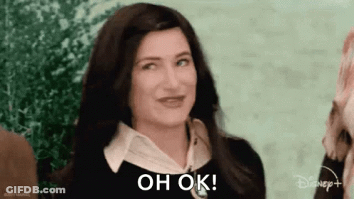 A Woman With Long Dark Hair Is Smiling And Says `` Oh Ok '' . GIF