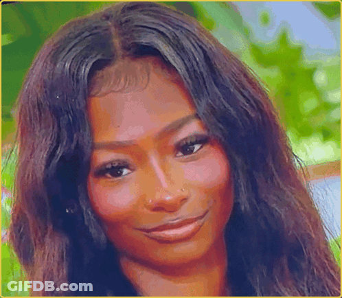 A Woman With Long Dark Hair Is Smiling For The Camera GIF