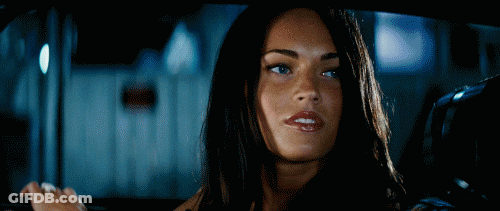 A Woman With Long Dark Hair Is Smiling While Sitting In A Car GIF