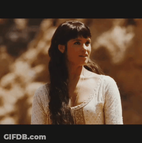 A Woman With Long Dark Hair Wearing A White Shirt GIF