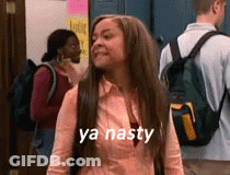 A Woman With Long Hair And A Backpack Is Standing In A Hallway With A Group Of People . GIF