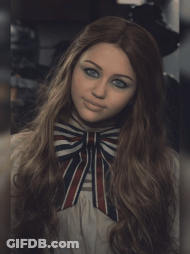 A Woman With Long Hair And Blue Eyes Wearing A Striped Bow Tie GIF