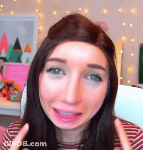 A Woman With Long Hair And Green Eyes Is Making A Funny Face GIF