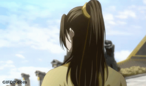 A Woman With Long Hair In A Ponytail Is Standing In Front Of A Building GIF
