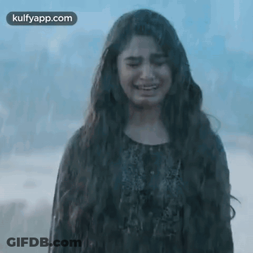 A Woman With Long Hair Is Crying While Standing On The Beach . GIF