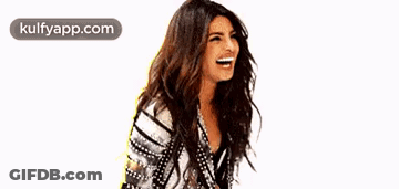 A Woman With Long Hair Is Laughing While Wearing A Striped Shirt . GIF