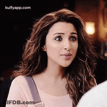 A Woman With Long Hair Is Making A Funny Face While Looking At A Man . GIF