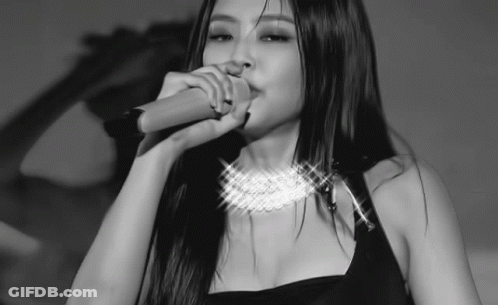 A Woman With Long Hair Is Singing Into A Microphone . GIF