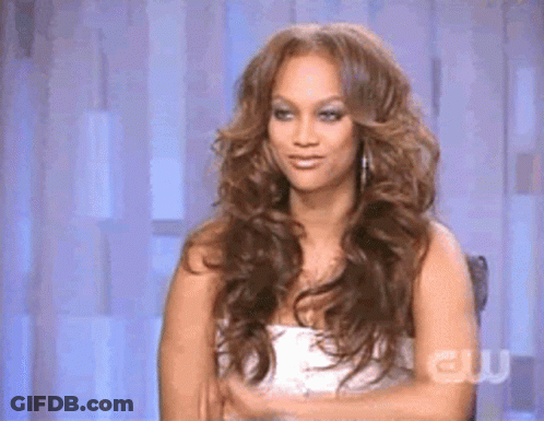 A Woman With Long Hair Is Sitting In A Chair With Her Arms Crossed . GIF