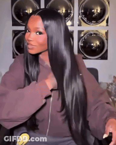 A Woman With Long Hair Is Sitting In Front Of A Laundromat . GIF