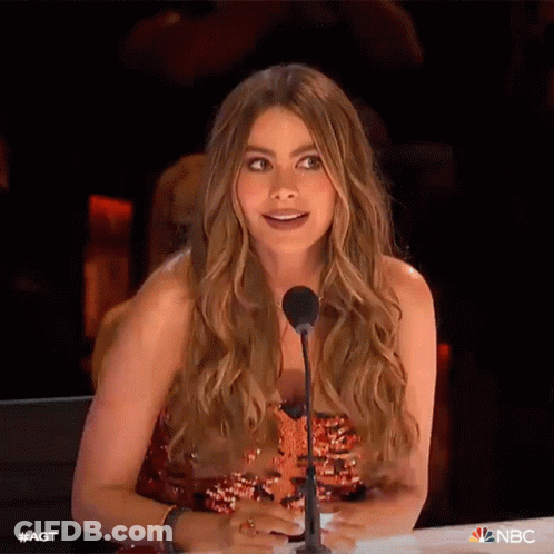 A Woman With Long Hair Is Sitting In Front Of A Microphone . GIF