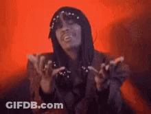 A Woman With Long Hair Is Smiling And Making A Funny Face While Sitting On A Couch . GIF