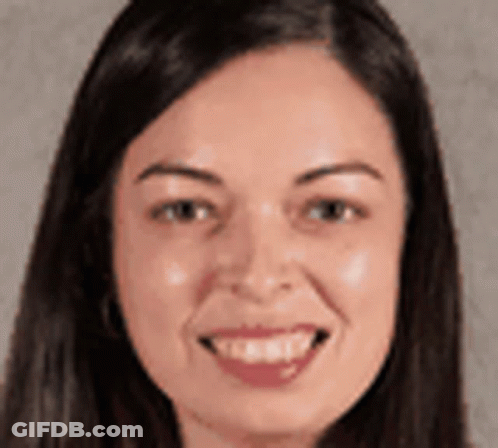 A Woman With Long Hair Is Smiling For The Camera . GIF