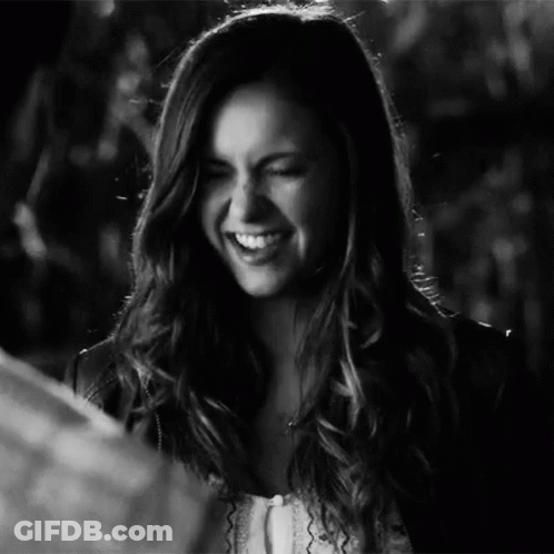 A Woman With Long Hair Is Smiling In A Black And White Photo . GIF