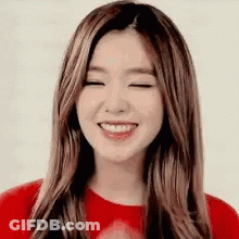 A Woman With Long Hair Is Smiling With Her Eyes Closed . GIF