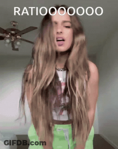 A Woman With Long Hair Is Standing In Front Of A Ceiling Fan With The Word Ratio Written On The Bottom GIF