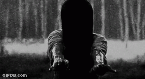 A Woman With Long Hair Is Standing In Front Of A Waterfall . GIF